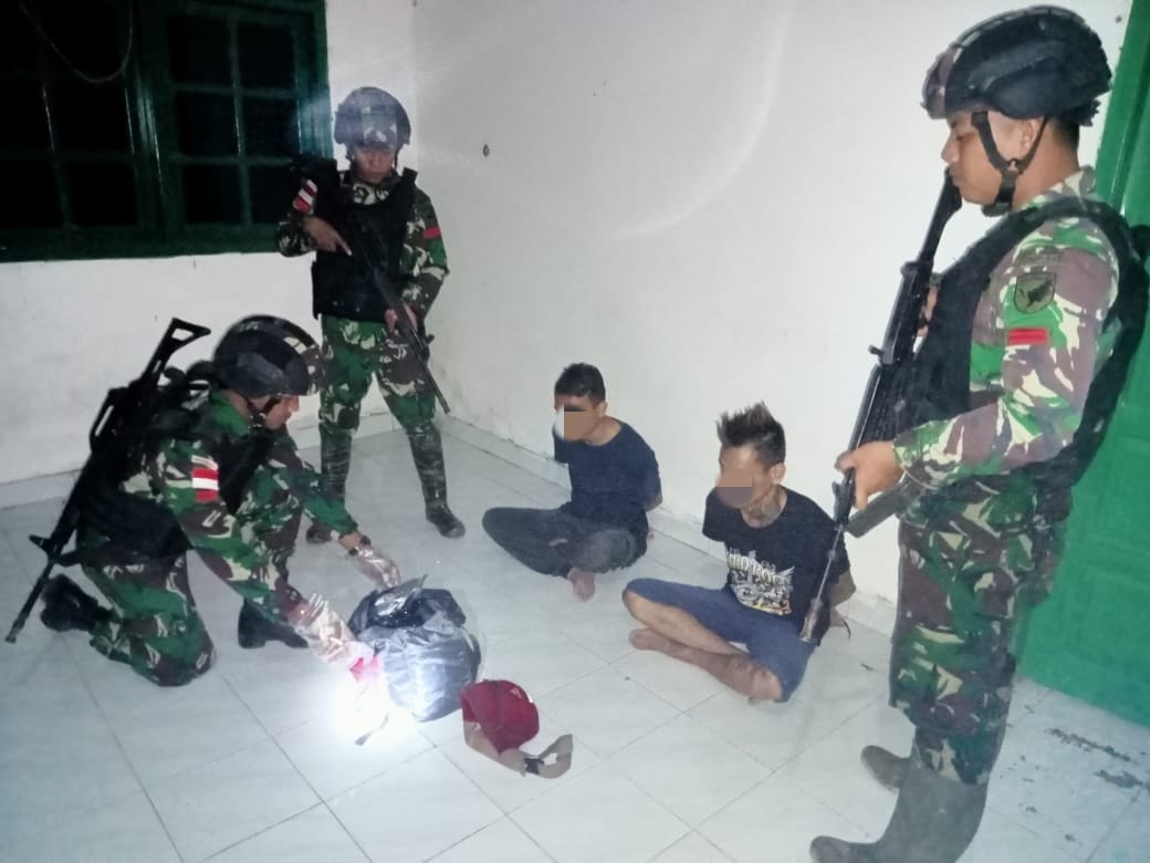 DITANGKAP : Dua terduga pelaku penyelundupan 7,1 kg sabu berhasil diamankan personel Pos Pamtas Sentabeng SSK II Satgas Yonif 645 Gty. (FOTO:ISTIMEWA)